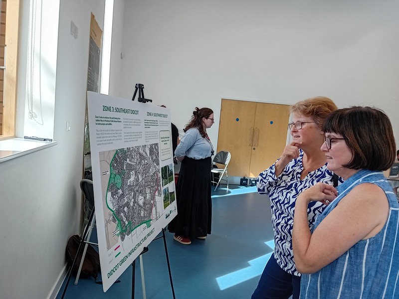 Two women looking at a  board displaying plans
