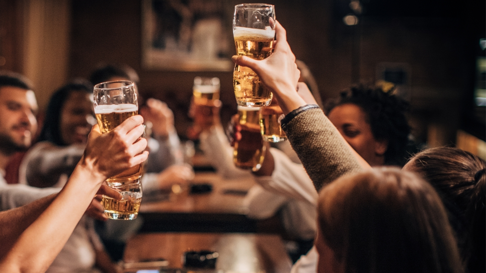 A photo of people raising glasses in a pub