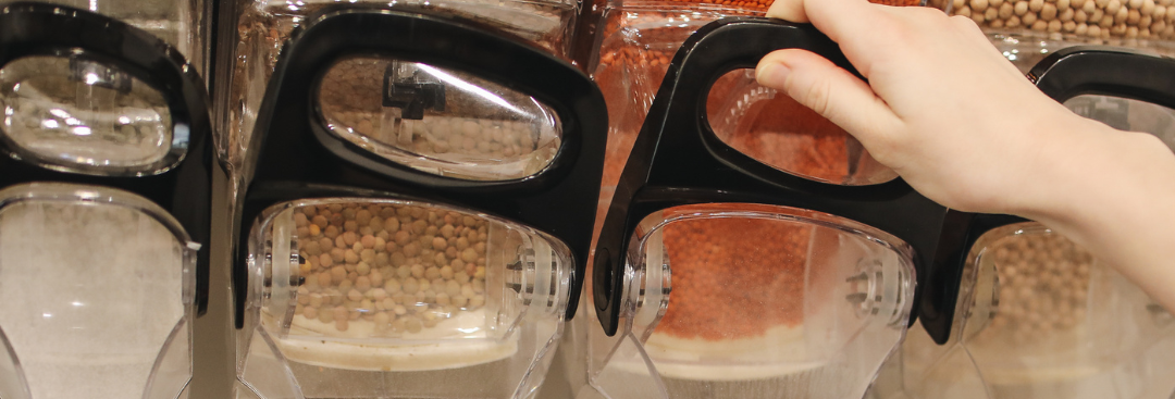 Person gets lentils from a refillable lentil jar in a refill shop