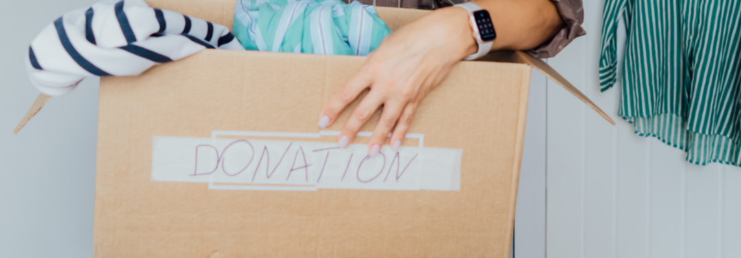 Woman holding clothes in a box with a donation label