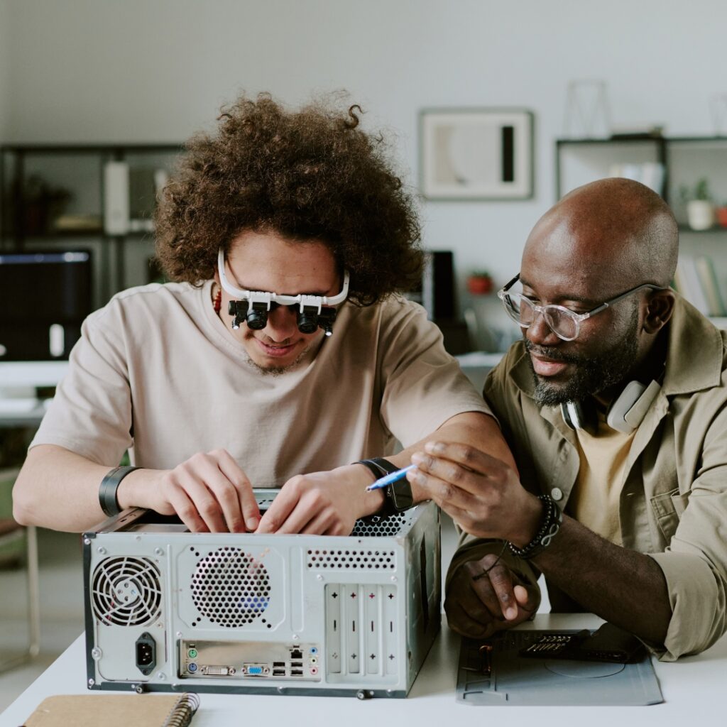 two people repairing an item