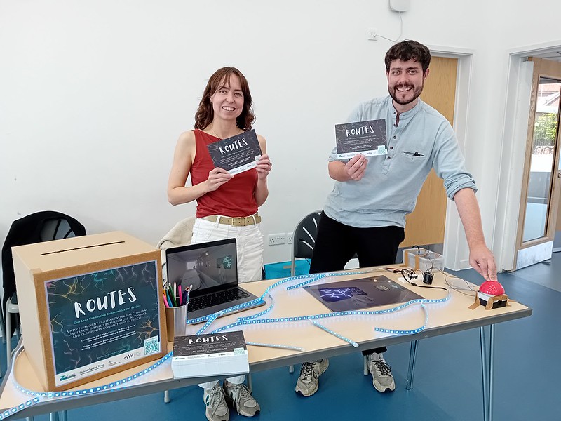 man and woman holding postcards promoting art project