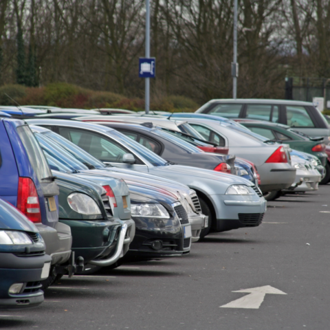Image of cars in a car park, with an arrow on the ground