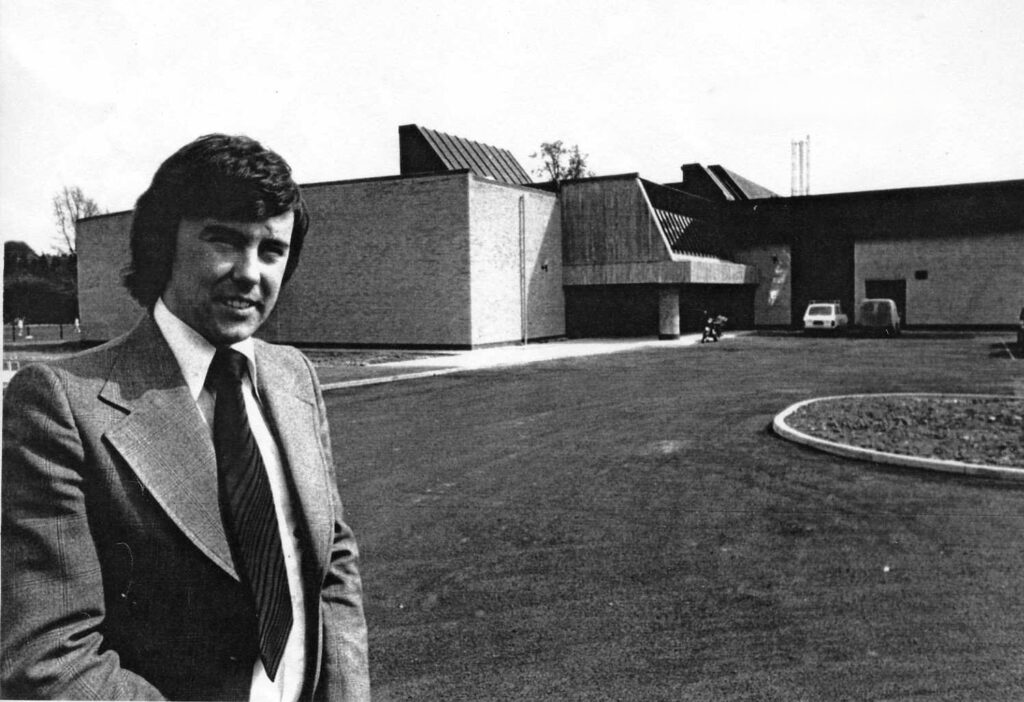 Black an white pic of a man standing outside a recreation centre